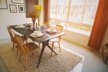Modern dining room interior with warm light from the sun. Relax day in dining room on free day and no activity. family time with food and enjoy in the family. dining room with table and spoon set.