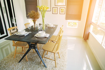 Modern dining room interior with warm light from the sun. Relax day in dining room on free day and no activity. family time with food and enjoy in the family. dining room with table and spoon set.