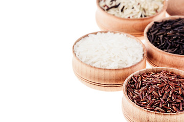 Red, black and white rice close-up in wood bowls on white background. Isolated. Rice texture background.