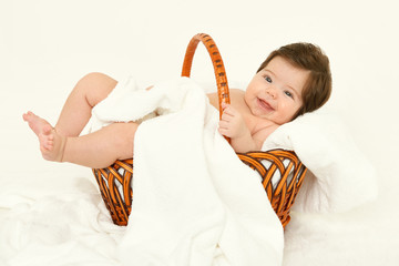 baby in basket on white towel, healthcare concept, yellow toned