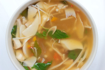Hot and Spicy Soup with mushroom, mix vegetable and Thai herbs in white bowl on white background ,Vegetarian Food, Healthy food