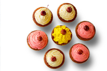 Top view of cupcakes. Cherry and colorful icing. Sweet treats for a company. Invite friends for dessert.