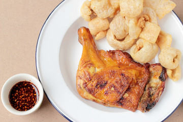 Streaky pork with crispy crackling and Grilled chicken leg with spicy sauce in small cup on wooden background. close-up. horizontal view from above. Thai Food