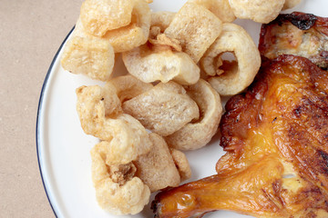 Streaky pork with crispy crackling and Grilled chicken leg in white dish on wood table. close-up....