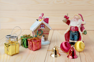 Santa Claus doll with gift boxes and gift decoration on pine wooden table for merry christmas and happy new year