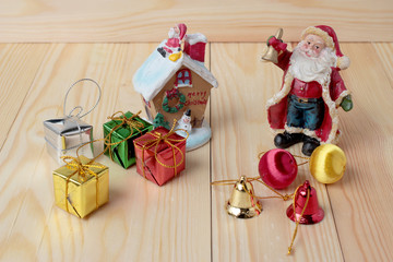 Santa Claus doll with gift boxes and gift decoration on pine wooden table for merry christmas and happy new year