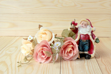 Santa Claus doll with Bunch of flowers on on pine wooden table for merry christmas and happy new year