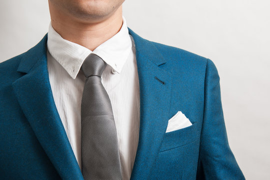 man in blue suit with silver necktie, white shite and pocket square
