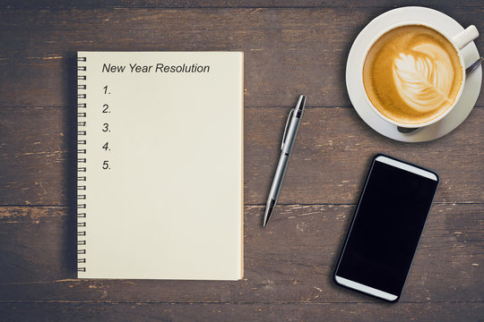 Business concept - Top view notebook writing New Year Resolution