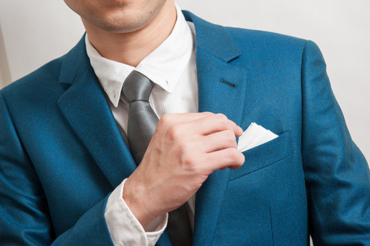 Man In Suit Taking Out The Pocket Square