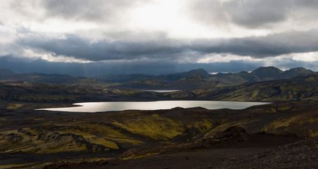 Iceland landscape with a lake and moss covered hills 