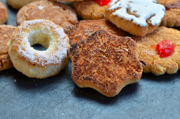 Close up of Mantecados, typical sweets consumed in Spain at Christmas. Spanish shortbread served on black stone board.