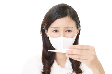 体温計で熱を測る女性