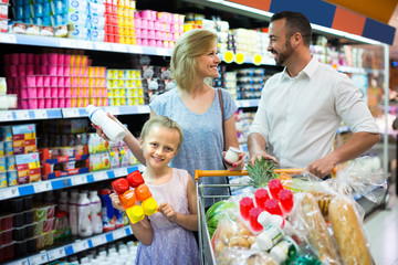 Family in dairy section in supermarket.