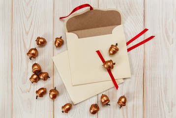 Christmas background.Envelopes with golden acorns.White wooden table.Mokup with empty space.Top view