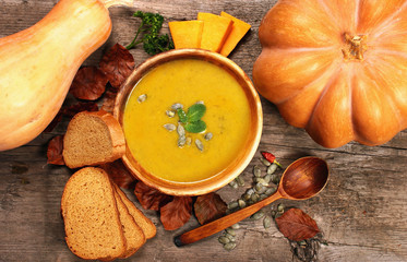 Pumpkin soup with spoon and bread