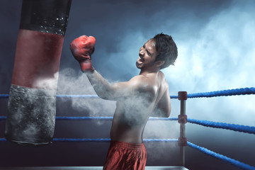 Asian man boxer practicing with punching bag