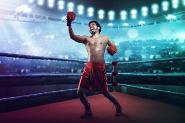 Muscular asian male boxer throwing an uppercut - obrazy, fototapety, plakaty