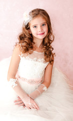 Fototapeta na wymiar Adorable smiling little girl in white princess dress