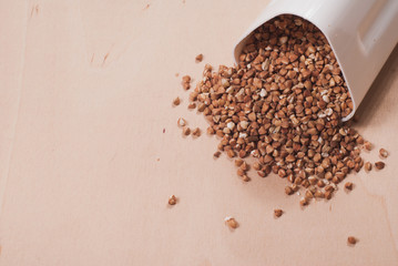 Buckwheat is scattered from the white container,