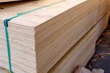 Sheets of stacked plywood in lumberyard. Shallow focus and blurred background. Copy space.
