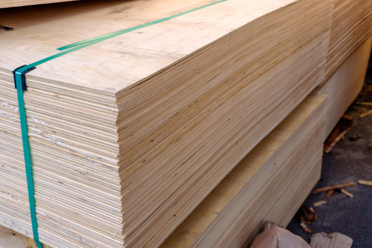 Sheets of stacked plywood in lumberyard. Shallow focus and blurred background. Copy space.