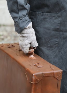 poor immigrant with old leather suitcase during the trip abroad