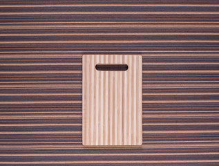 cutting board on a striped tablecloth, brown white colors