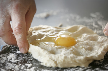 Male hands making fresh dough on table
