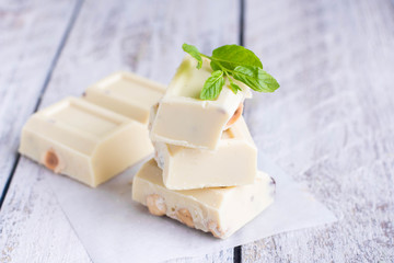 White chocolate with nut on a white wood background. Copy space
