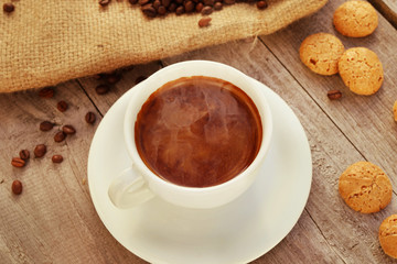 Cup of hot coffee on wooden surface