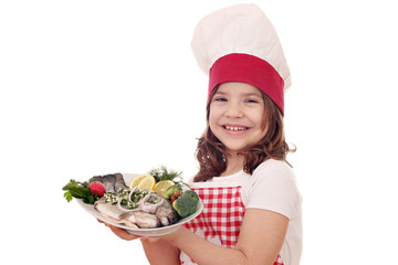 happy little girl cook with trout fish