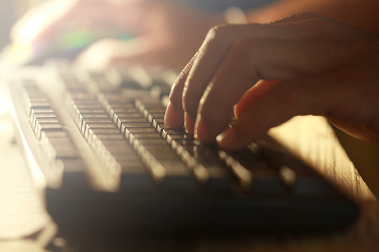 Hand of man use keyboard working at night scene.