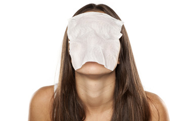 young woman with a wet tissue over her face