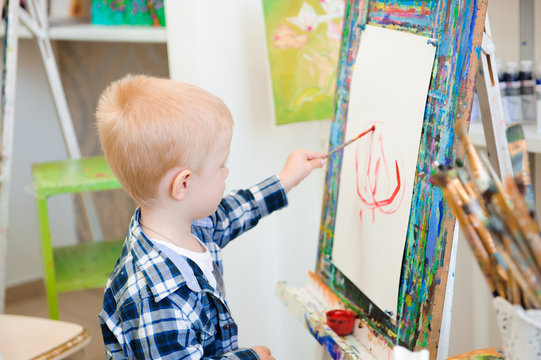 a child draws a picture paints on art lesson