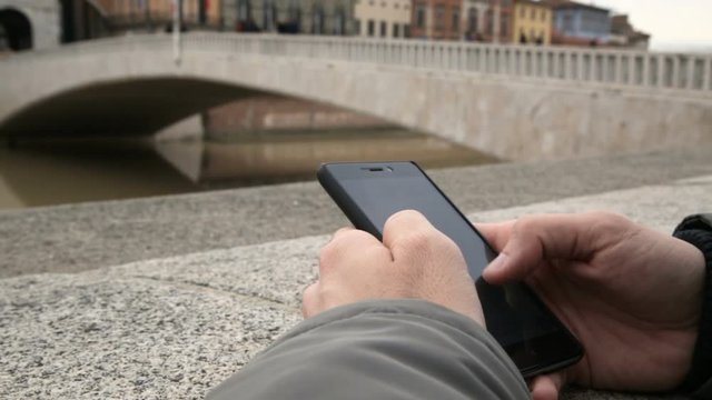 Using a smartphone against the bridge on the Cement wall