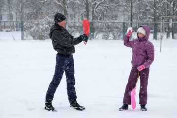 Teenage boy and a young girl playing snowballs