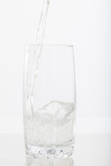 Pouring water into a glass half full