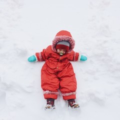 happy baby play on snow. winter game concept
