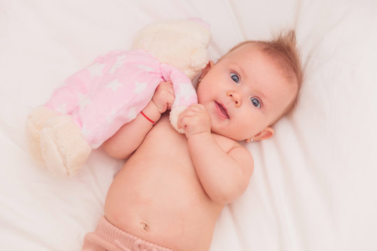 Baby Girl With Mohawk Hairstyle Playing With Teddy Bear