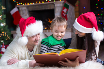 Friendly family reading book on Christmas evening