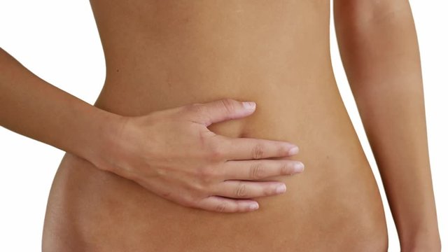 Young white girl having stomach problems on a white background. Millennial Caucasian woman with a stomach ache on a blank backdrop