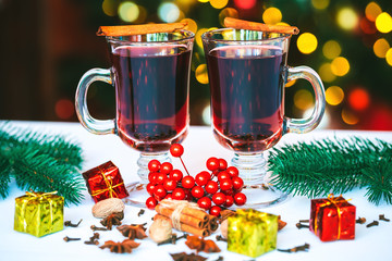 Beautiful Two glasses of mulled wine on bokeh background decorated Christmas tree. The idea for postcards. Soft focus. Shallow DOF