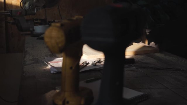 Carpenter grind wooden plank in his workshop
