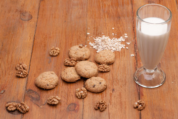 Oatmeal cookies and glass of milk on wooden old boards