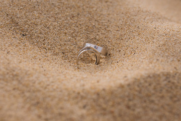 white gold wedding rings on the sand
