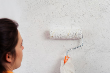 Female painter decorating the wall with roller