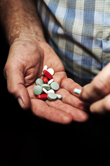 Colorful medical pills in senior male hands