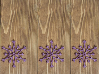 Sparkling snowflake Christmas decoration on wooden background.