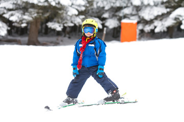 Fototapeta na wymiar Cute little boy, learning to ski in Austrian ski resort
